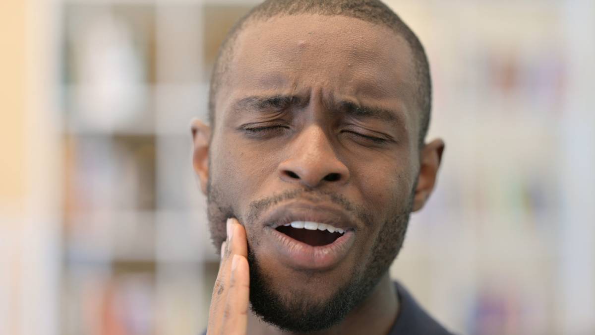 Man experiencing pain from tooth infections.