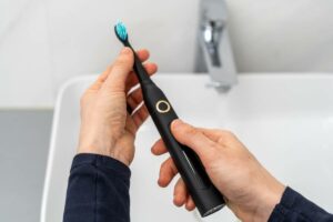 Person holding one of their electronic toothbrushes