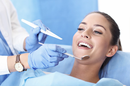 Woman having teeth examined at dentists